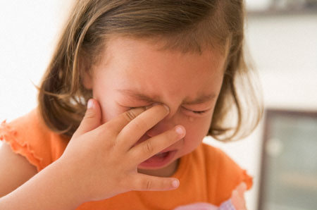 Young girl indoors crying