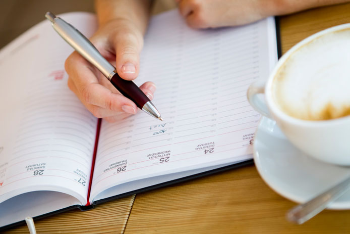 Close up of woman writing in planner